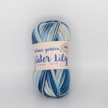 「PLUS WOOL（プラスウール）」ボタニックガーデンシリーズのソックヤーン。スイレン（Water Lily）をイメージした、ブルー、ホワイト、ライトグレーの段染め（グラデーション）カラーの毛糸玉。
